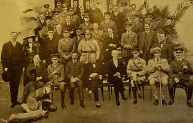 Photo souvenir prise devant l’hôtel Sémiramis, où figurent trente-neuf militaires et civils entourant Churchill. Gertrude Bell est la seule femme du groupe.